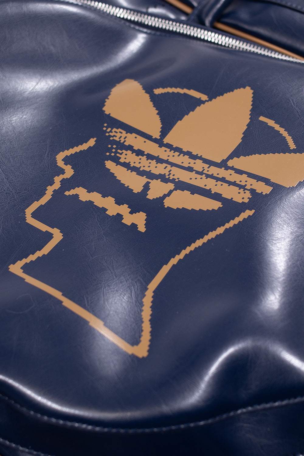 Detailaufnahme der Adidas x Brain Dead Tasche mit kreativem Zipper-Design und hochwertiger Polyurethan-Außenseite.