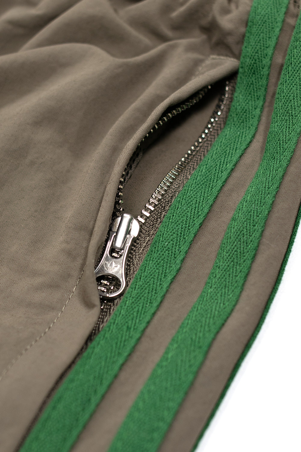 Adidas Brain Dead Kollaboration: Track Pants im klassischen Schnitt mit künstlerischem Crossover-Design auf dem Bein.