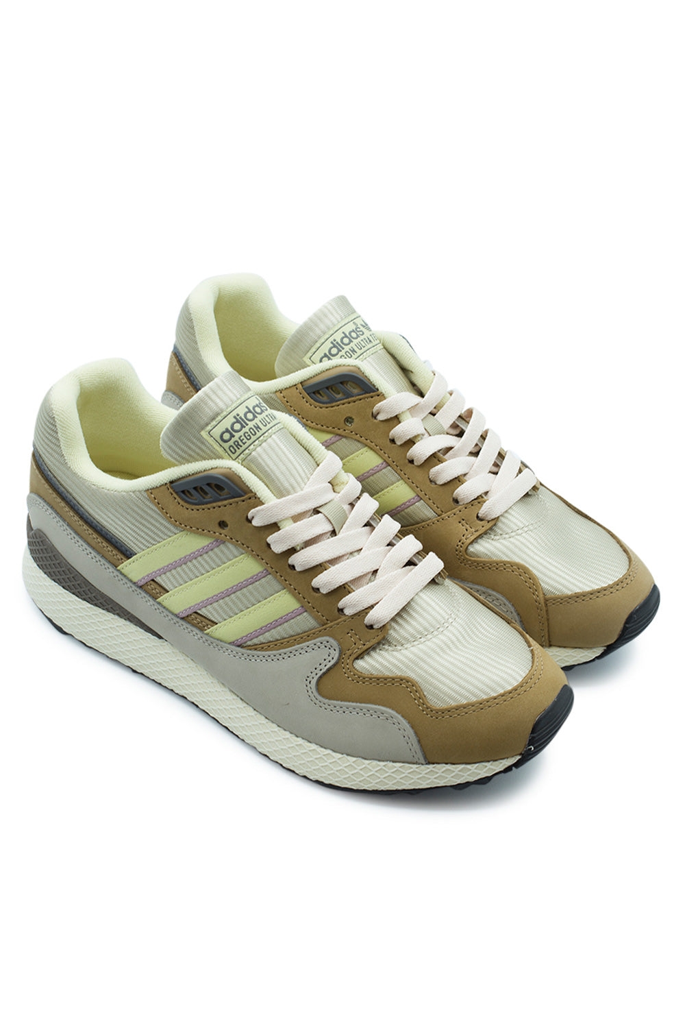 Elevated three-quarter studio angle of the Adidas Oregon Ultra Tech in Tech Met / Dual Yellow / Cardboard, showcasing the early-1990s marathon running silhouette, multi-textured nubuck and textile paneling, and trail-inspired vintage aesthetic