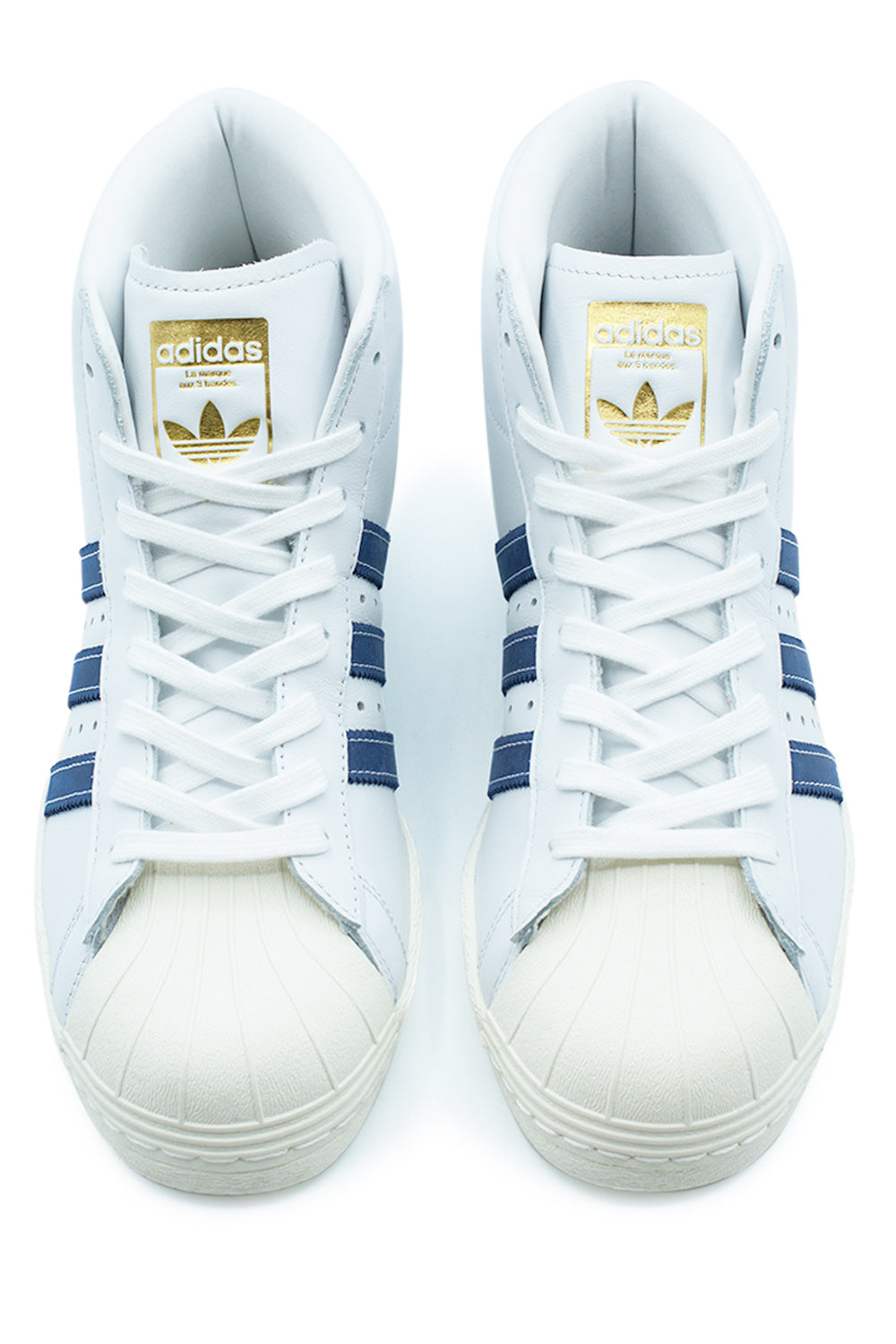 Top-down view of a pair of adidas Pro Model 80 ADV shoes, highlighting the white lacing system, classic off-white rubber shell toe, and gold tongue tags.
