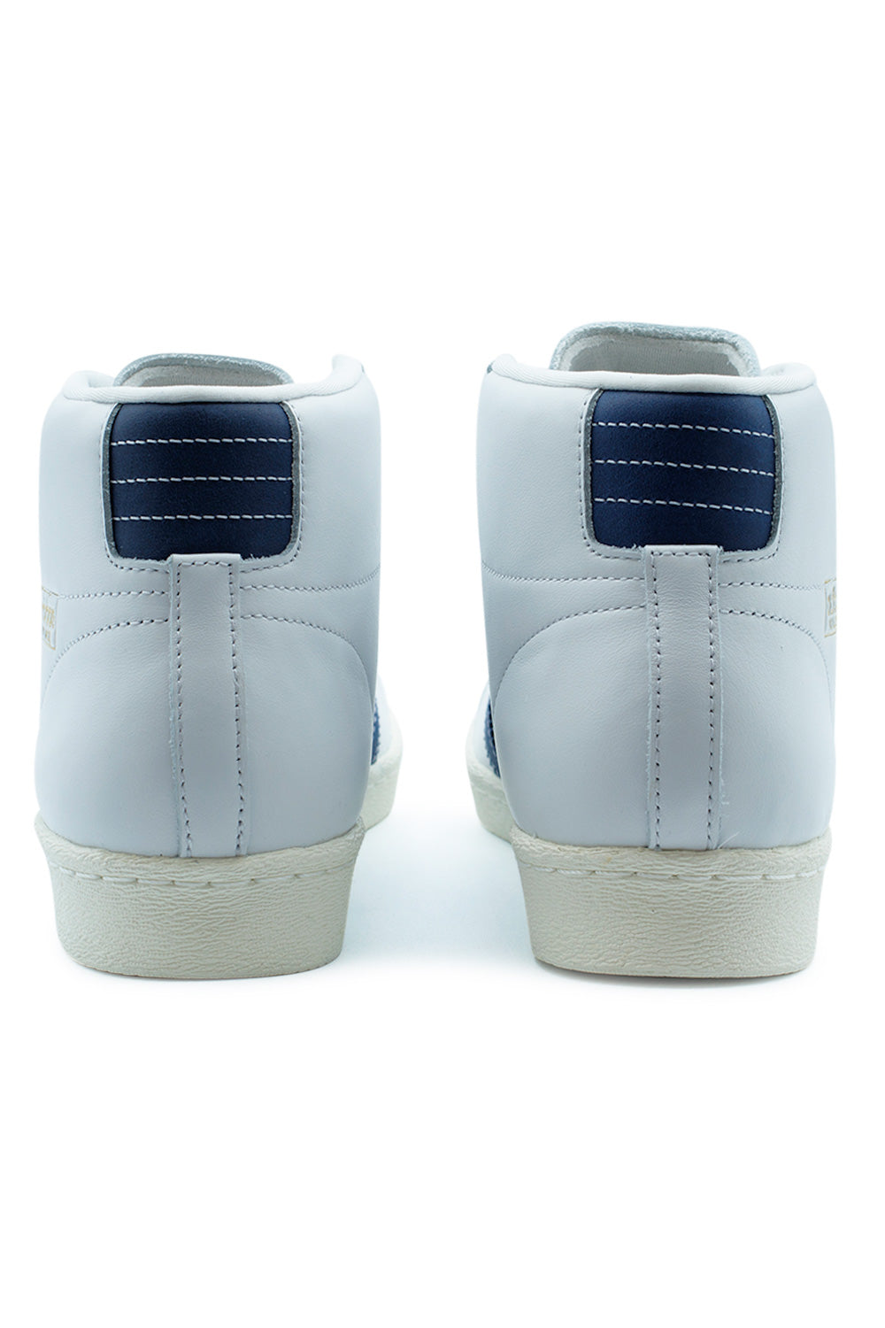 Rear heel view of the adidas Pro Model 80 ADV sneakers, showing the muted purple nubuck heel tabs with clean white horizontal stitched lines.