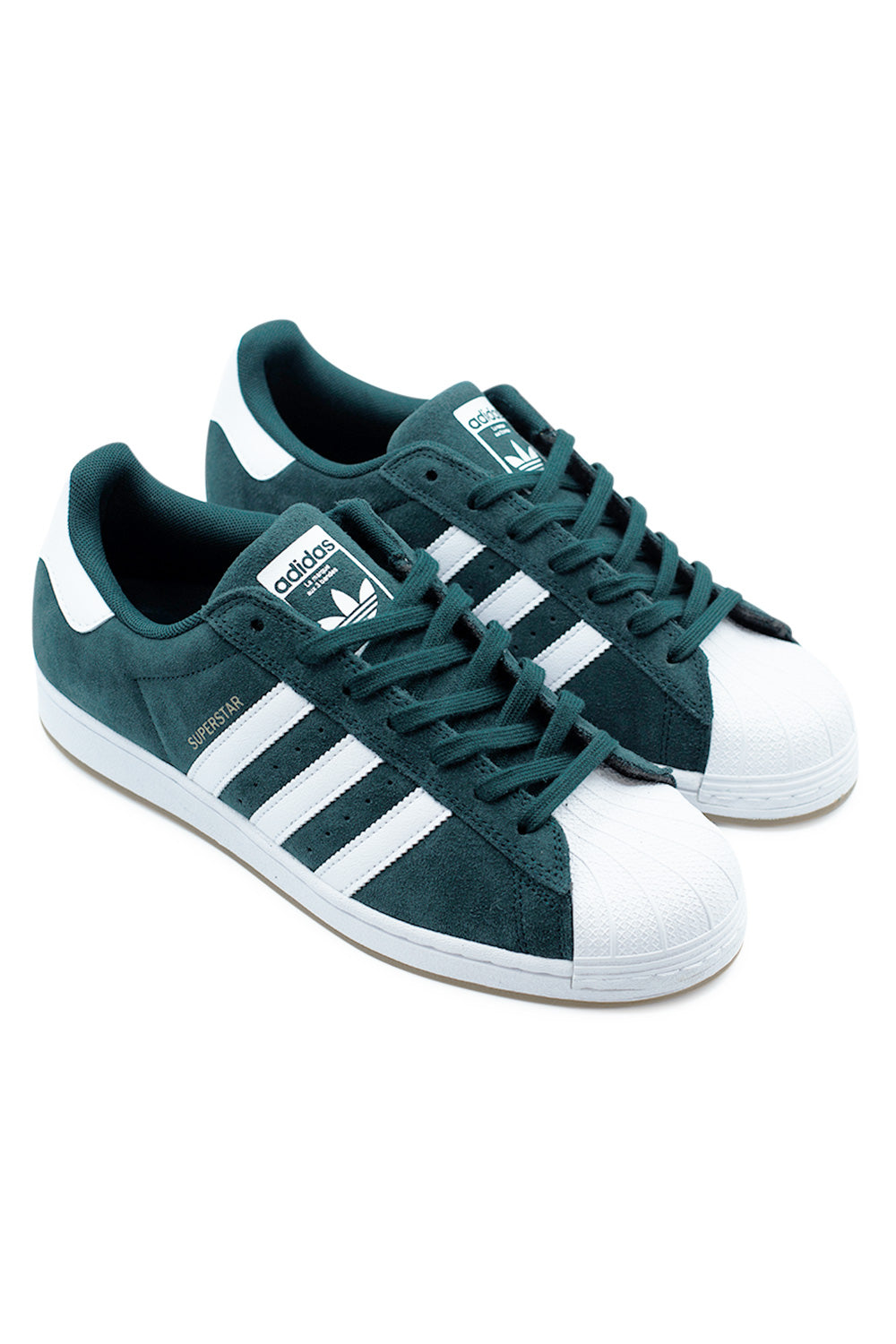 Angled pair of Adidas Superstar ADV Aurora Ivy Cloud White Gold Metallic skateboarding sneakers showcasing green suede upper, gold Superstar lettering and iconic shell toe streetwear design