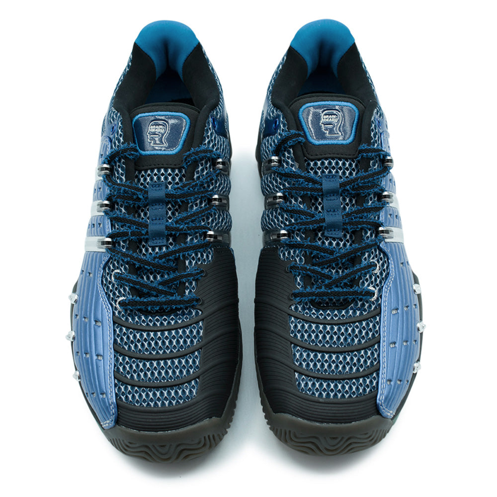 Top-down overhead studio shot of the adidas x Brain Dead Barricade V pair, detailing the asymmetrical forefoot layout with heavy-duty ribbed black rubber drag guards, two-tone woven laces, breathable space-age blue mesh, and translucent glossy blue Brain Dead head silhouette logo badges stitched onto both padded tongues.