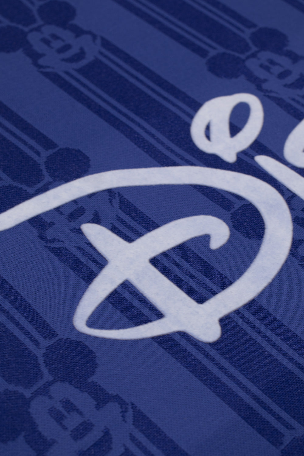 Close-up of the flocked Disney lettering on the adidas x Brain Dead x Disney Football Jersey Victory Blue highlighting premium textured print, retro football aesthetic and limited capsule collaboration