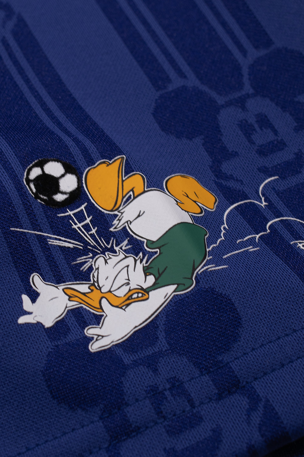 Close-up of the printed Donald Duck football graphic on the sleeve of the adidas x Brain Dead x Disney Football Jersey Victory Blue highlighting exclusive Disney artwork and collectible collaboration details