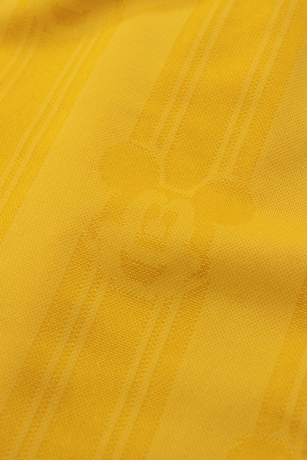 Close-up of the all over woven Mickey Mouse jacquard pattern on the adidas x Brain Dead x Disney Football Short Bold Gold showcasing premium textured polyester fabric inspired by classic 1990s World Cup football kits and exclusive Disney collaboration