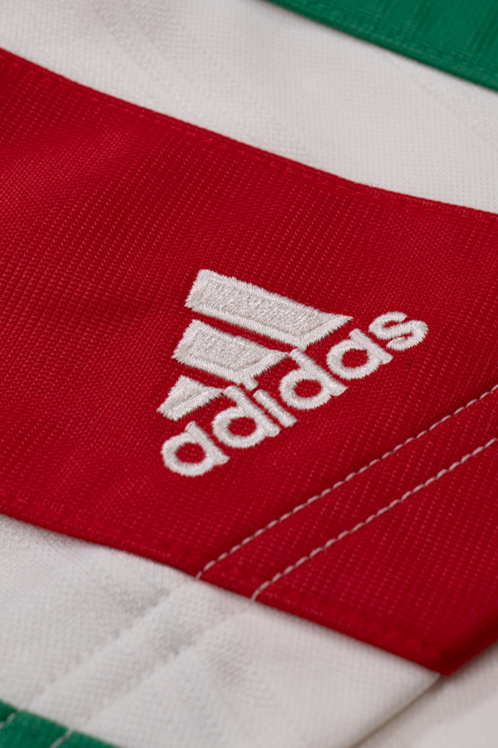 Close-up of the embroidered adidas logo on the adidas x Brain Dead x Disney Football Short Crystal White showcasing sewn-on three stripe panels, premium embroidery and vintage football styling