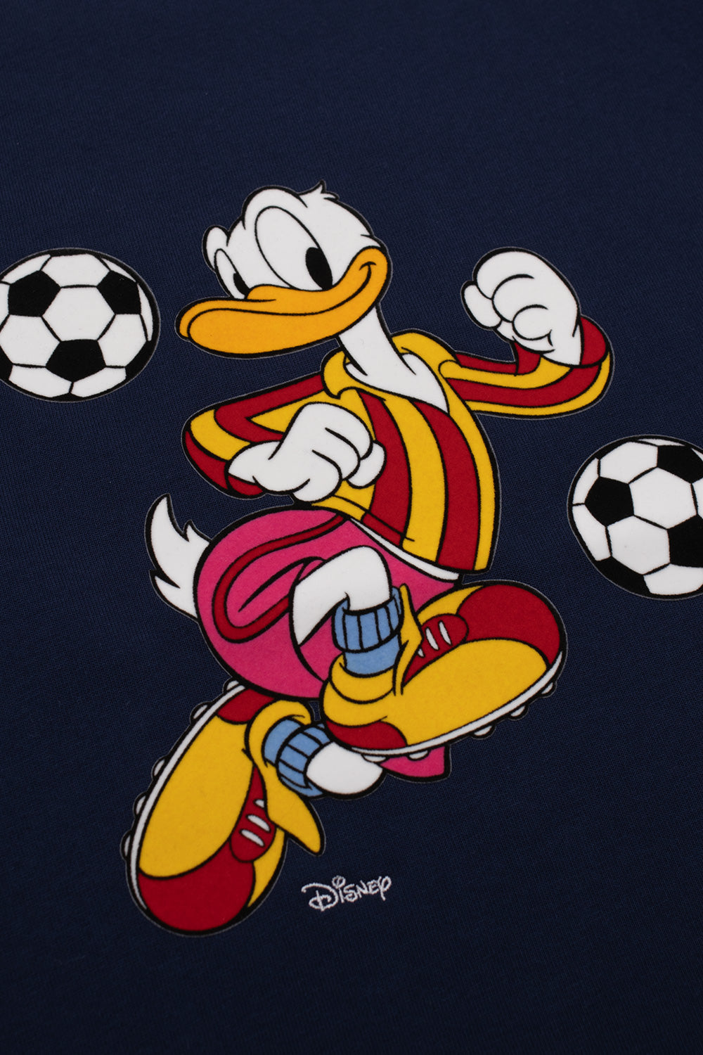 Detailed flock print of Donald Duck juggling footballs on the Adidas x Brain Dead x Disney Core Navy T-Shirt, celebrating 90s World Cup nostalgia with classic Disney artwork, premium textured graphics and collectible collaborative apparel.