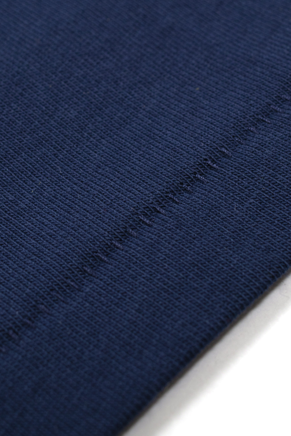 Close-up of the vintage single stitched hem on the Adidas x Brain Dead x Disney Core Navy T-Shirt, emphasizing heritage-inspired construction, heavyweight 100% cotton jersey, retro sportswear craftsmanship and premium finishing details.