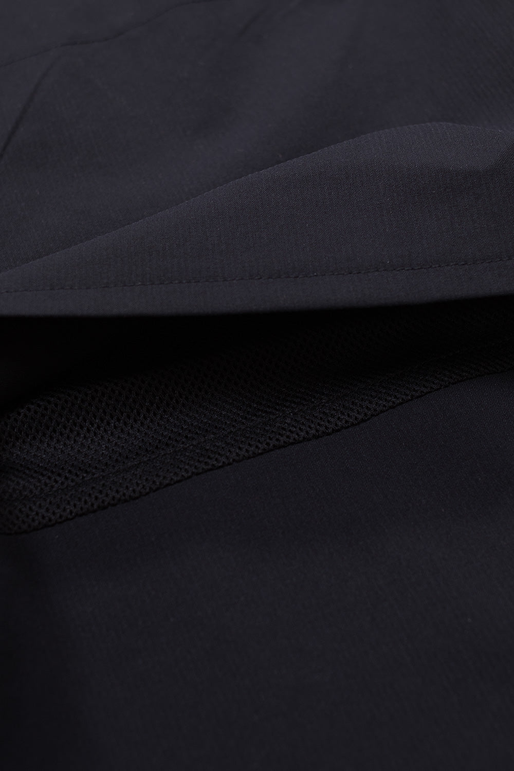 Macro texture shot of Adidas Metalwood black performance trousers fabric, durable stretch-woven polyester material surface designed for flexibility, golf movement, and everyday comfort