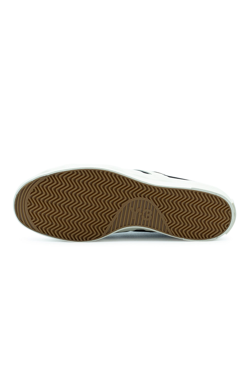 Full bottom view of the gum rubber herringbone tread outsole on the Adidas Y-3 Nisi Lo sneaker, showing the wavy traction pattern and an embossed Y-3 logo in the center arch zone.