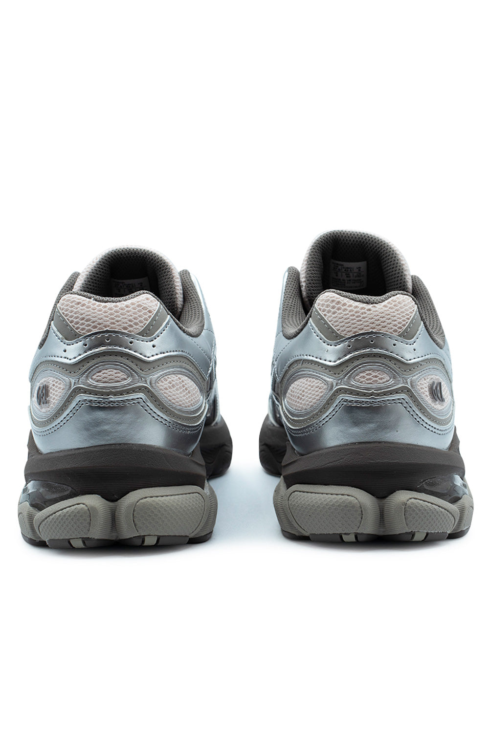 Rear perspective shot of the heels of the Asics Gel-NYC 2.0 sneakers, highlighting the padded grey textile collars, ventilated Pink Cloud mesh inserts, curving metallic silver synthetic overlays with embossed GEL branding, and segmented dark grey and light grey rubber outsoles with beveled heels.