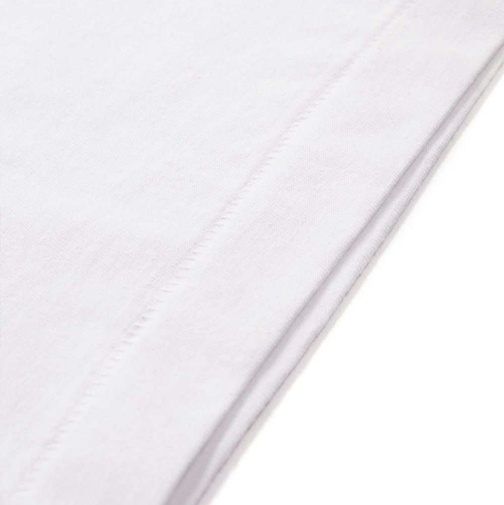 Extreme macro close-up of the bottom hem on the white BoTT Ultra T-Shirt, focusing on the neat blind-stitch edge seam and the dense, premium knit texture of the heavyweight white cotton jersey.