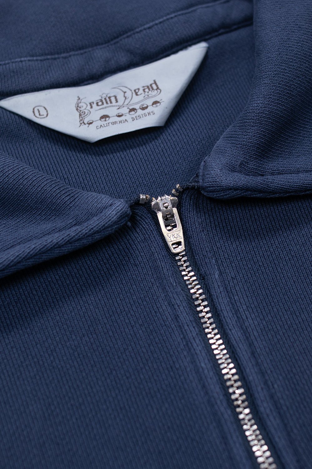 Close-up of Brain Dead Half Zip Collared Sweatshirt Midnight highlighting metal YKK zipper, structured collar and soft french terry cotton texture from the Los Angeles streetwear brand
