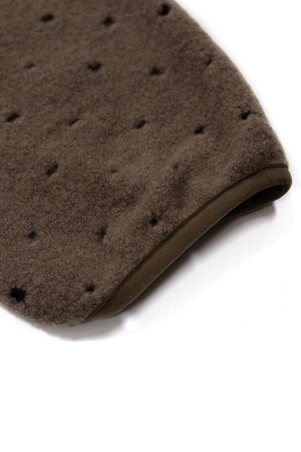 Close-up of the Brain Dead Hole Mock Neck Pullover Brown sleeve showcasing laser-cut perforated wool blend fabric, relaxed oversized fit and premium streetwear construction