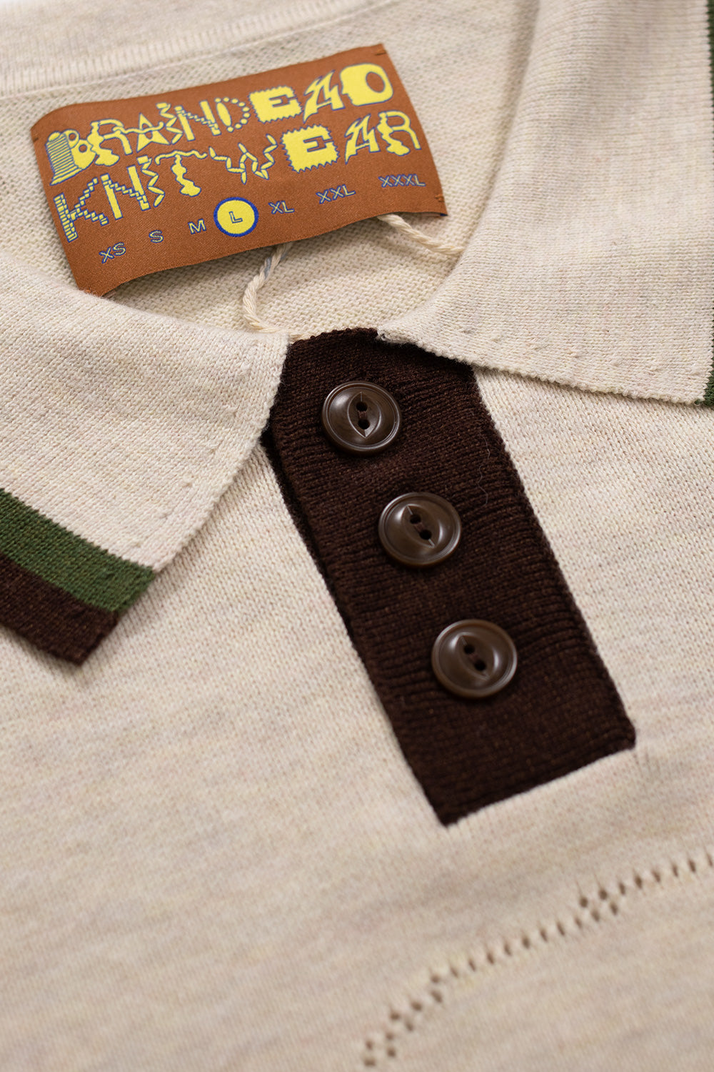 Brain Dead Pointelle Polo Natural – Luftiges Baumwoll-Polo mit gewebtem Logo auf der Brust und lockerer, kastiger Passform.