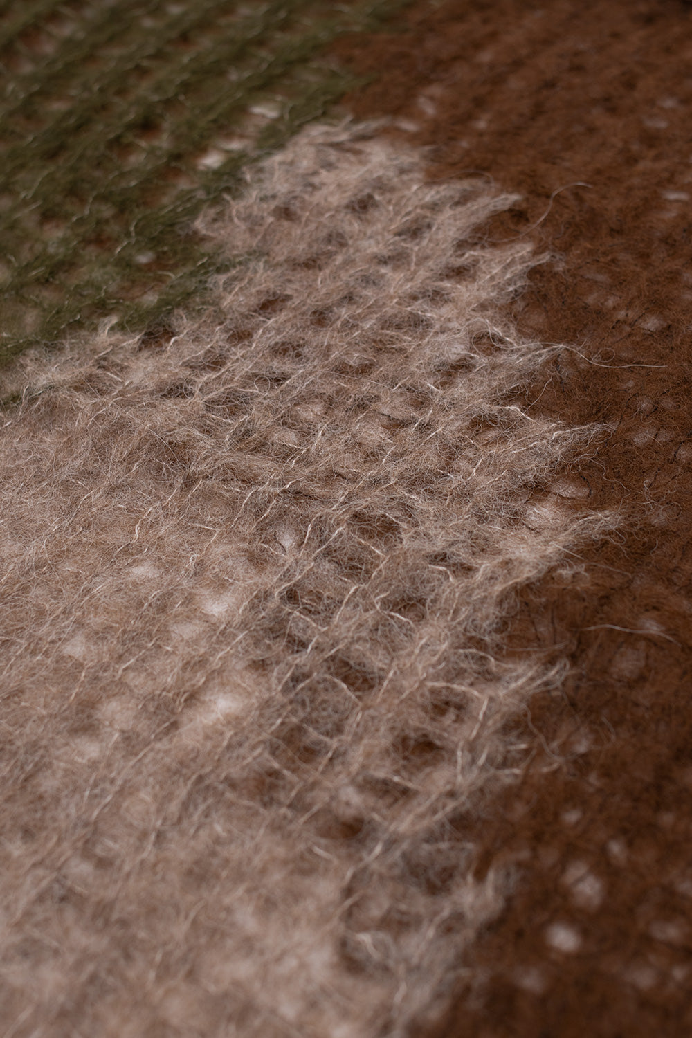 Detailed macro of Brain Dead Organic Threadbare Sweater Olive highlighting ultra-fine open knit structure, soft alpaca fiber blend and breathable transparent weave on premium streetwear knitwear
