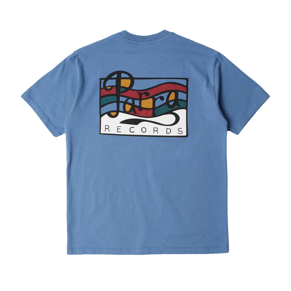 Back flat lay studio view of the By Parra Records T-Shirt in cornflower blue, showcasing a relaxed streetwear cut tailored from soft cotton jersey, centered by a large rectangular pop-art screen print of a record label motif with flowing musical stave lines in red, teal green, orange, and white behind black cursive "Parra" lettering above "RECORDS" typography.