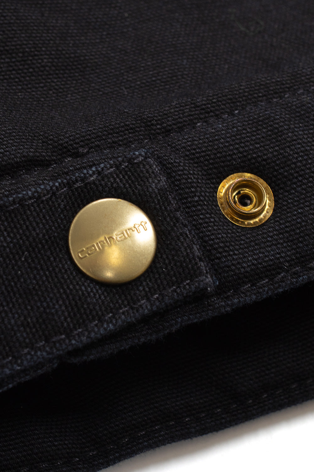 "Nahaufnahme der Carhartt WIP OG Detroit Jacket in Black/Black Aged Canvas – robuste Verarbeitung und zeitlose Details, inspiriert von traditioneller Workwear"