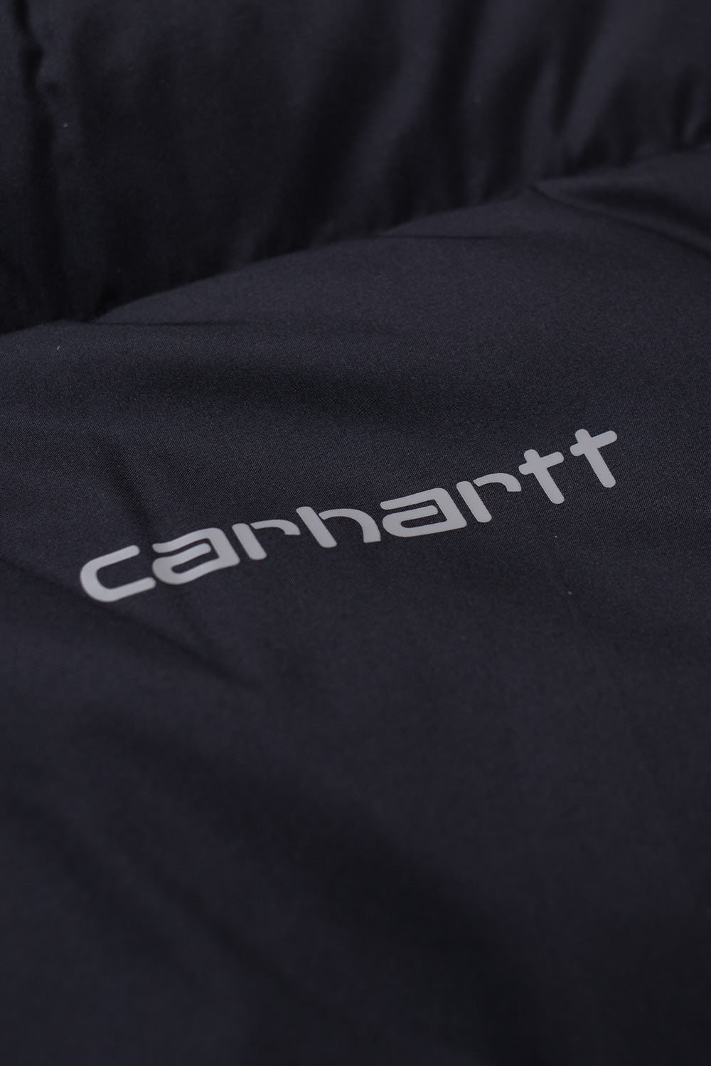 "Detailaufnahme der Carhartt WIP Springfield Jacket in Black/Blacksmith – gewebtes Carhartt-Logo auf der Brusttasche für dezente Markenakzente"