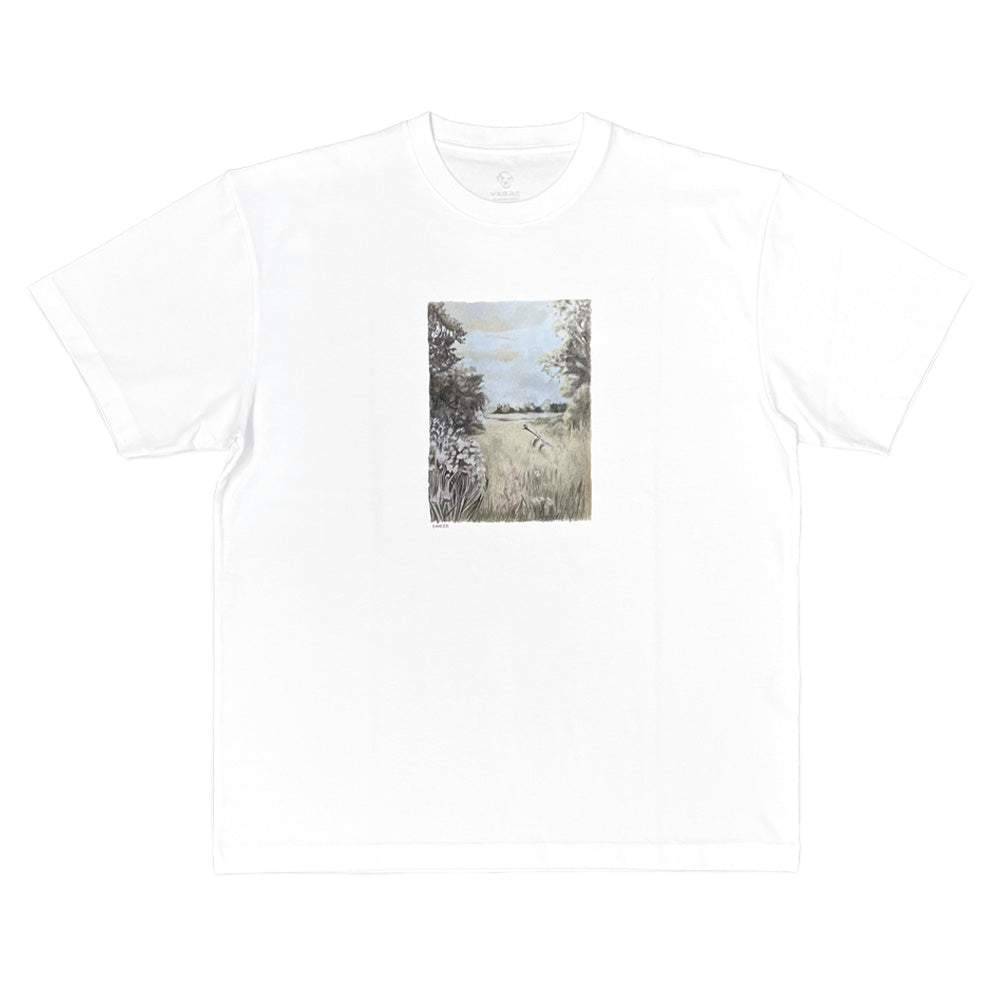 Front flat lay studio view of the Dancer Flute T-Shirt in clean white, showcasing a relaxed boxy short-sleeve skate tee made from soft cotton jersey, featuring a ribbed crew neckline, straight hemline, and a centered vertical rectangular art print depicting a pastoral grassy field landscape with a flute lying among meadow flowers.