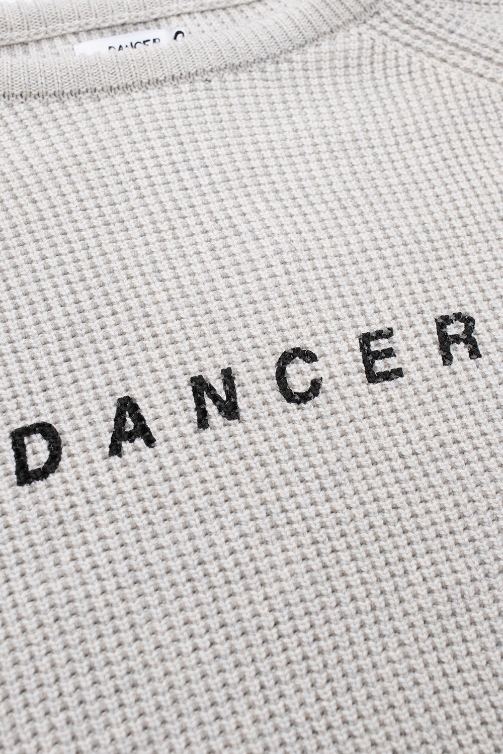 "Dancer Logo Cotton Knit Pullover in Cream – hochwertiger, cremiger Baumwollpullover mit auffälligem Logo auf der Vorderseite"
