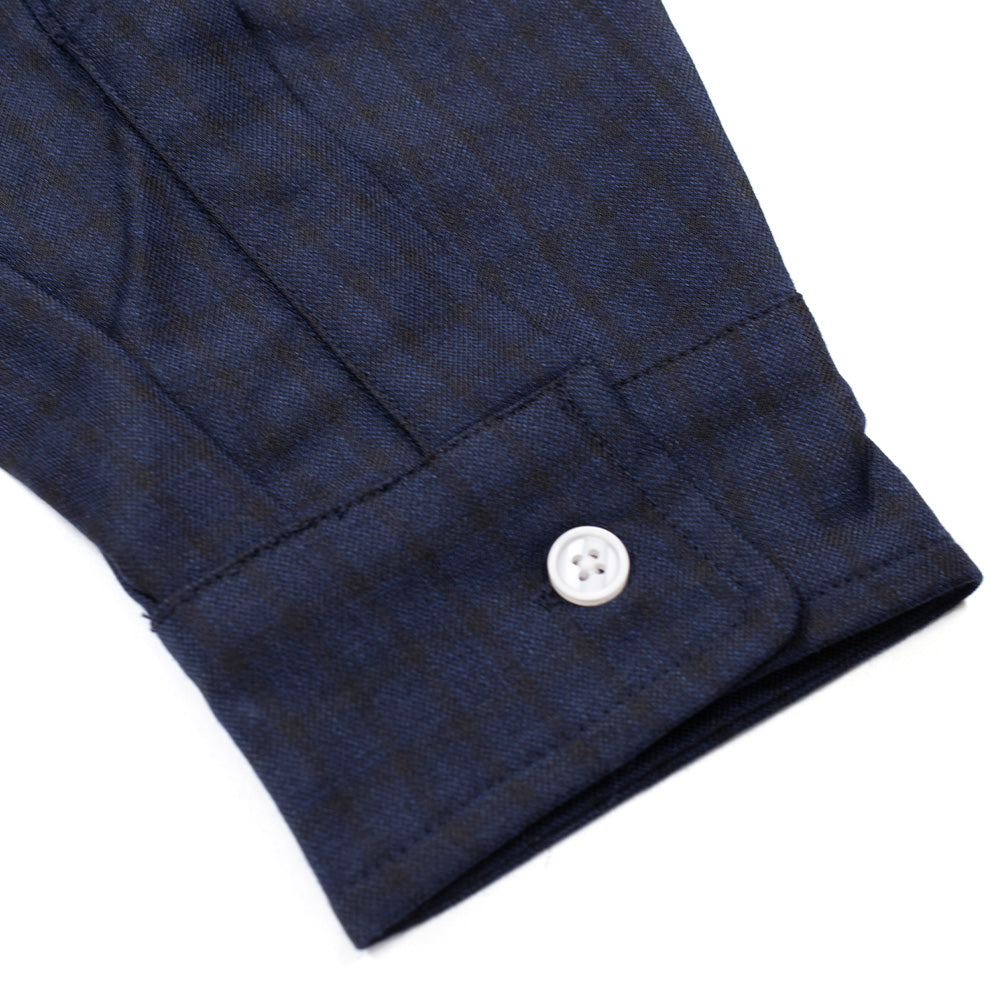 Macro studio perspective of the sleeve cuff on the Dancer Split Checked Shirt in Navy, detailing the textured dark navy micro-check fabric weave, tailored gauntlet pleating, clean tonal stitching, and a single white button closure.