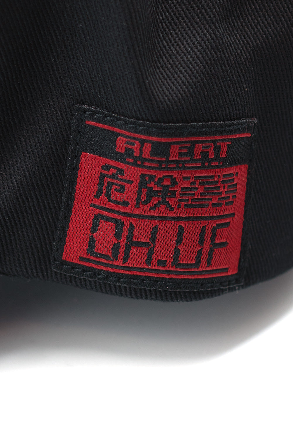 Detailed view of sewn-on side patch on HUF x Metal Gear Solid black snapback, showcasing collectible streetwear design and gaming heritage