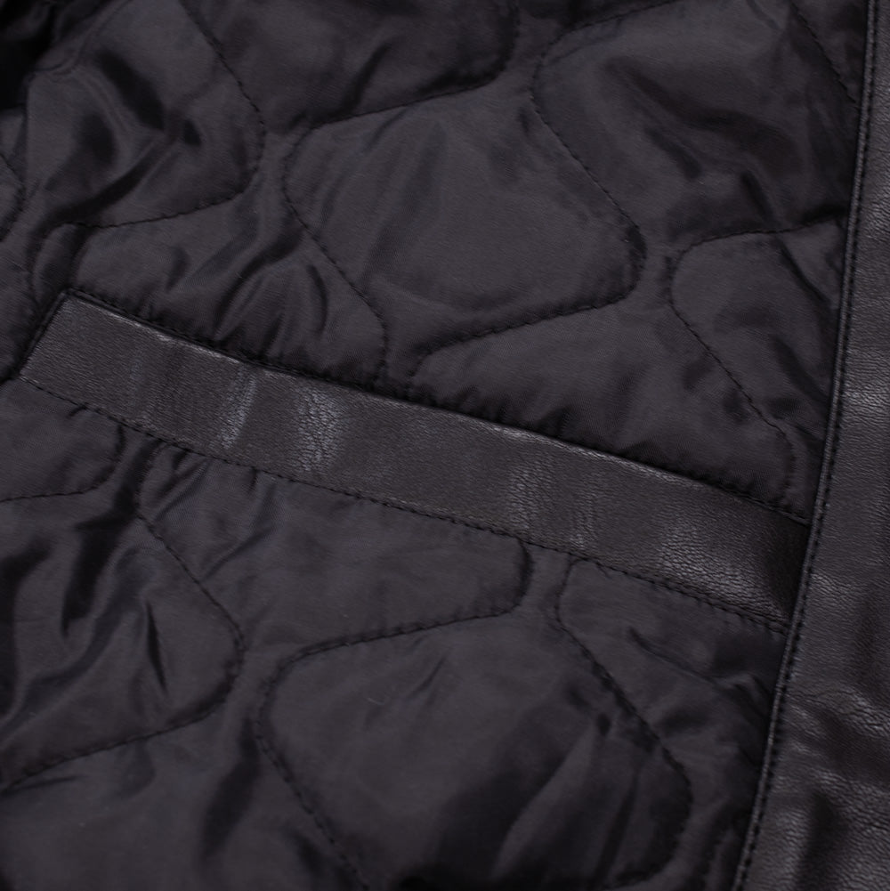 Interior studio detail of the Huf X Three 6 Mafia jacket, revealing the smooth black diamond-quilted padded lining and the inner welt pocket trimmed with matching black faux leather.