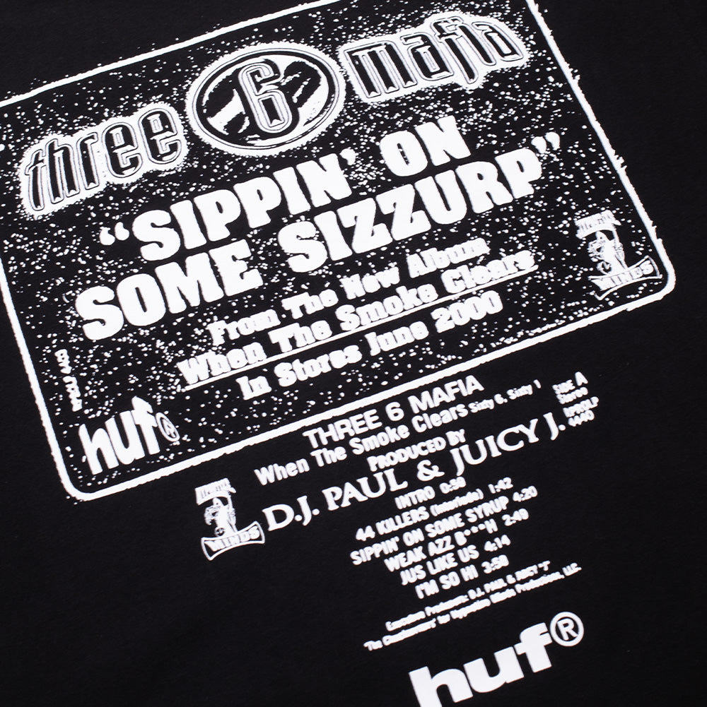 Detailed studio close-up of the back graphic print on the Huf X Three 6 Mafia Sizzurp T-Shirt, emphasizing the distressed cassette single cover artwork reading "SIPPIN' ON SOME SIZZURP", "In Stores June 2000", production credits for D.J. Paul & Juicy J, and the clean white "huf®" emblem.