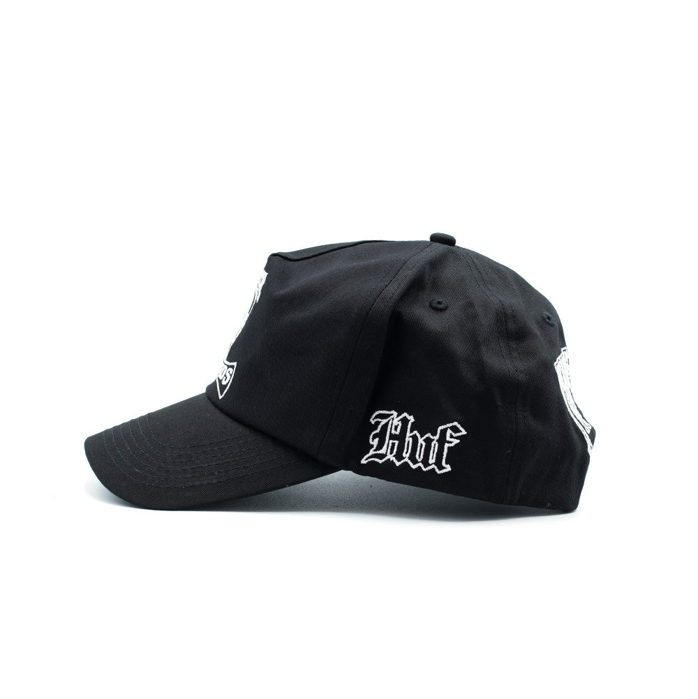 Left side profile view of the black HUF x Three 6 Mafia Snapback cap, detailing the six-panel structured cotton shape, sewn eyelets, clean visor curvature, and crisp white Old English gothic script embroidery of the "HUF" brand logo on the lower side panel.