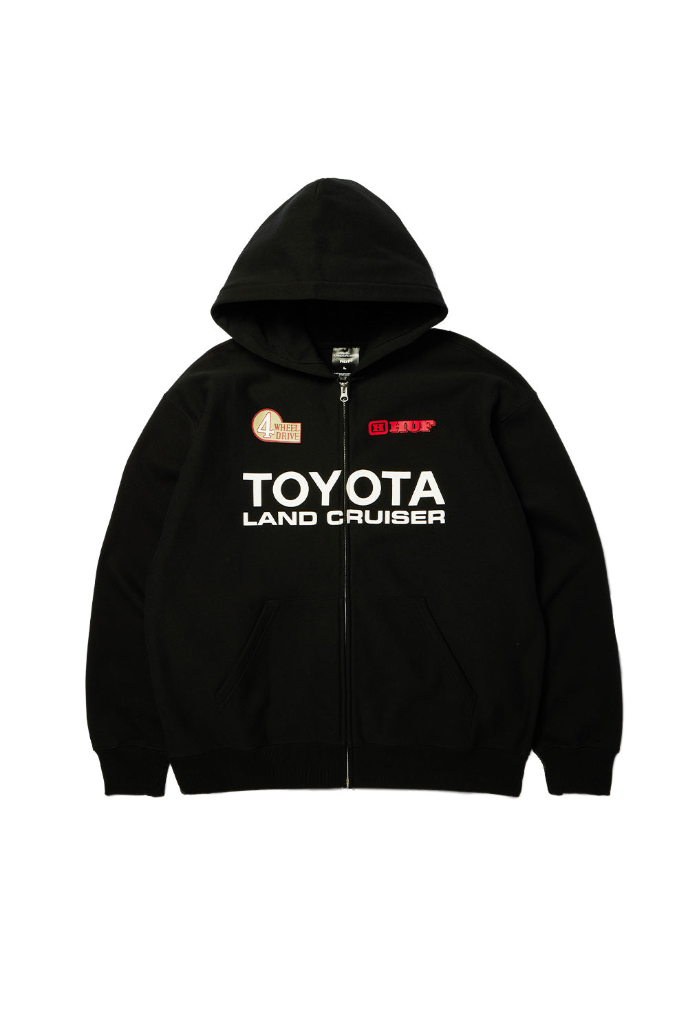 Front flat lay view of the black Huf X Toyota Land Cruiser Heavyweight FZ Hoodie in 420g cotton fleece, featuring a loose fit silhouette with a double-layered drawstring hood, full metal YKK front zipper, split kangaroo pocket, bold white "TOYOTA LAND CRUISER" chest branding, a red "4 WHEEL DRIVE" vintage graphic badge on the right chest, and a red framed HUF logo on the left chest.