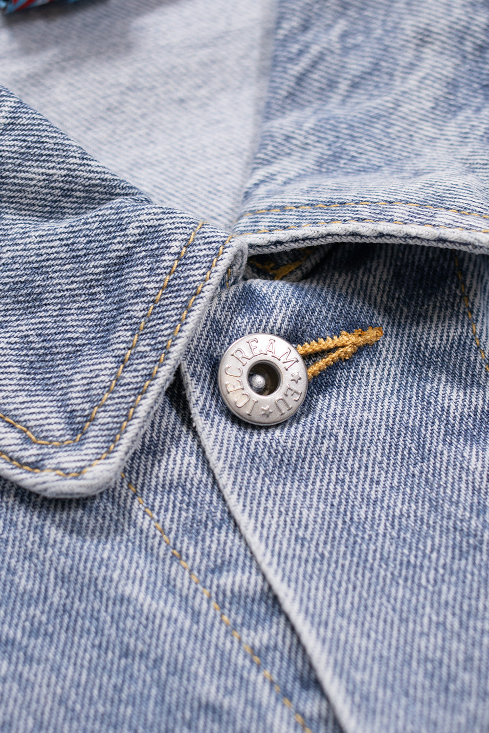 Light wash blue denim jacket featuring Ice Cream's red running dog logo on the back