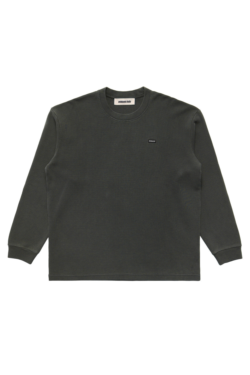 Metalwood Studio Mini Metal Logo Thermal Shirt Tar – wide-fit waffle knit long sleeve in dark tar color with minimalist sewn chest patch, 100% cotton streetwear top inspired by golf and skate culture.