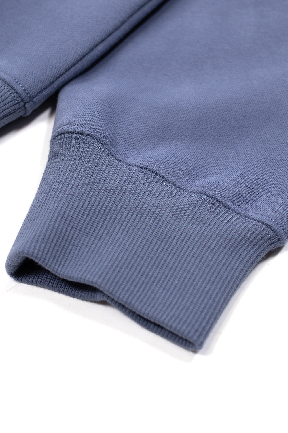 Ribbed sleeve cuff detail of the Metalwood Studio Woodlite Hoodie in steel blue, showcasing heavy cotton-blend construction and durable knit finish.