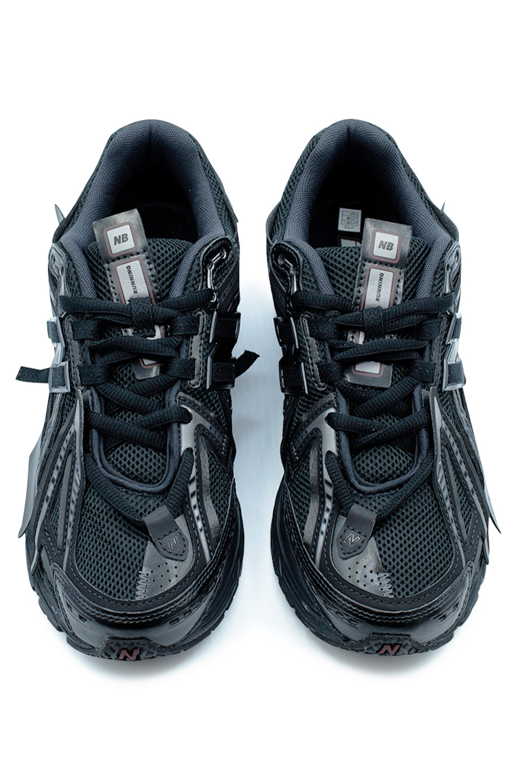 Front-facing look at the New Balance 1906A Black / Dark Silver Metallic sneaker showcasing the open-engineered mesh construction, asymmetrical overlay layout, N-Lock lacing system, padded collar and modern performance-inspired running silhouette.