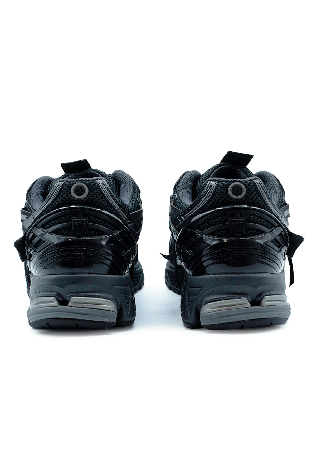 Rear profile of the New Balance 1906A M1906AF highlighting the sculpted TPU heel cage, segmented ABZORB SBS cushioning, breathable mesh heel panel and monochrome Black and Phantom colorway with Dark Silver Metallic accents.