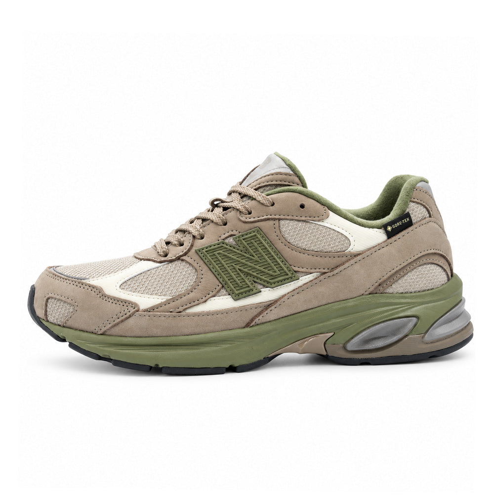 Lateral profile studio view of the New Balance 2010 (GORE-TEX) sneaker in Mushroom and Timberwolf, highlighting the waterproof low-top lifestyle running silhouette with earthy beige and tan nubuck overlays, durable mesh base, textured olive green N logo, woven GORE-TEX label at the collar, muted green ABZORB midsole, and metallic silver ABZORB SBS heel cushioning pod inserts.