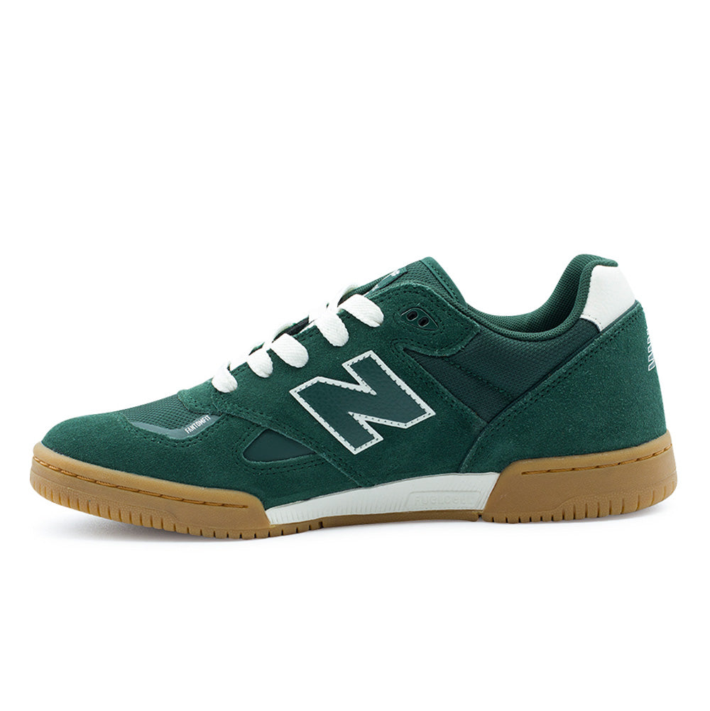 Medial side profile view of the New Balance Numeric Tom Knox 600, showcasing the streamlined arch contour, clean green suede panelling, white leather N emblem, bonded eyelet reinforcement, and the white FuelCell foam midsole insert embedded into the gum rubber sole unit.