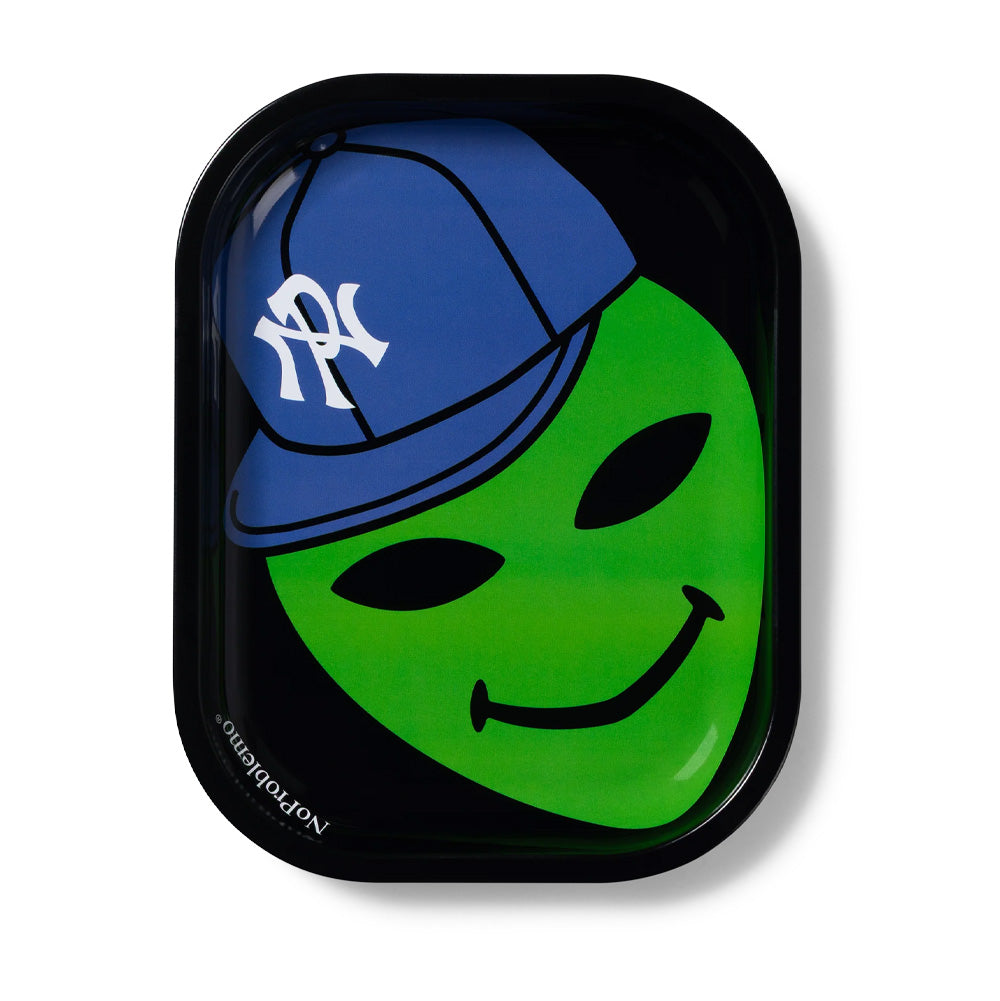 Top-down studio flat lay view of the rectangular Aries No Problemo Alien Dude Metal Tray in Black, showcasing curved raised edges, high-gloss enamel finish, a bold white No Problemo slogan printed on the left rim, and a vibrant graphic featuring a smiling green alien wearing a royal blue baseball cap with an intertwined white NP monogram logo.