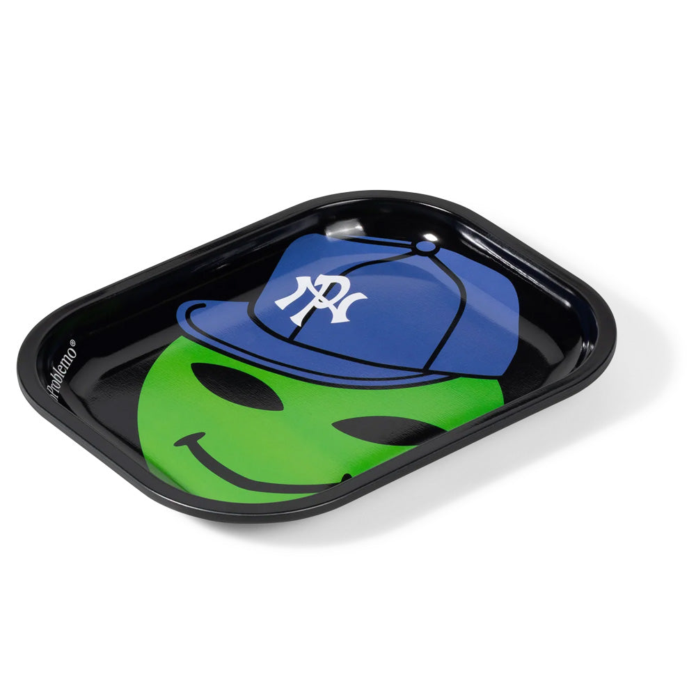 Perspective studio view of the glossy black Aries No Problemo Alien Dude metal rolling and valet tray, displaying the smooth rounded lip, shallow catch-all dish depth, and colorful central pop-art illustration of a cartoon green extraterrestrial head in a tilted blue cap.