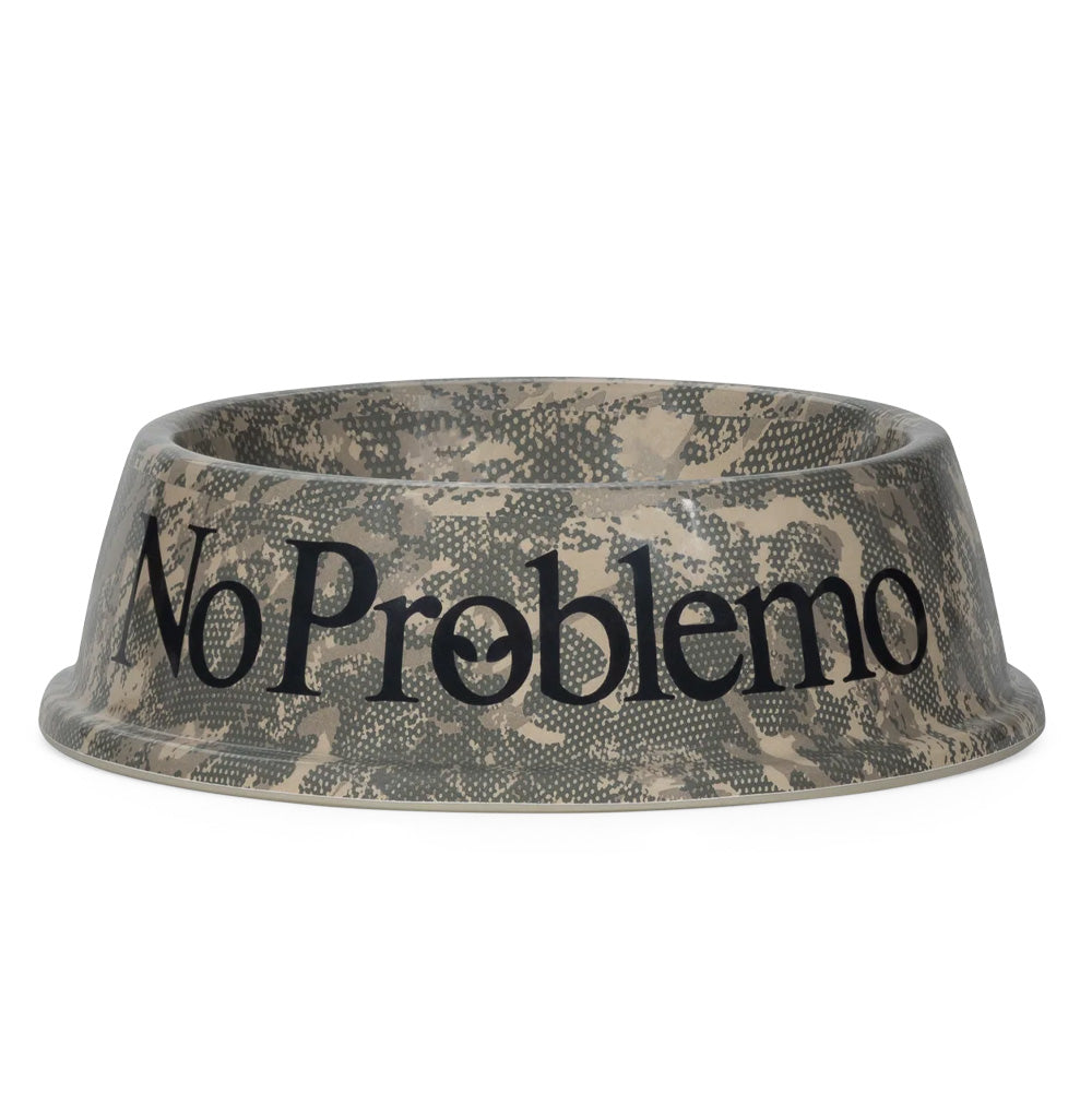 Side perspective studio shot of the Aries No Problemo Pet Bowl in all-over digital camouflage, showcasing the durable curved melamine dog and cat feeding dish decorated in olive drab, beige, and grey pixelated camo pattern with bold black serif "No Problemo" typography printed across the front.