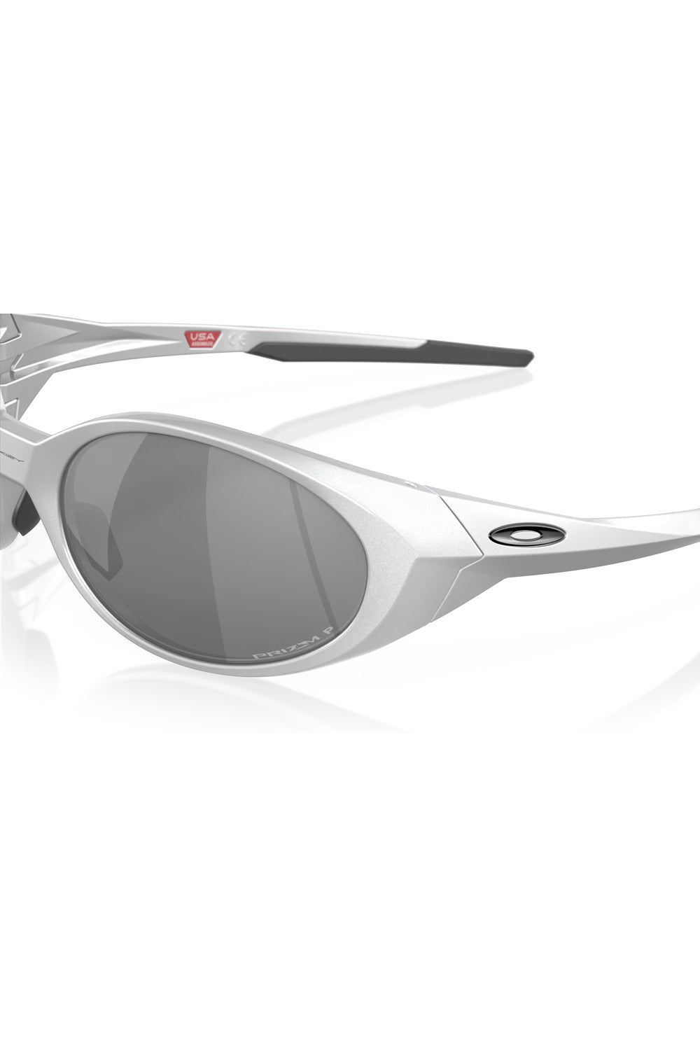 Close-up detail of the silver Oakley Eye Jacket Redux temple hinge area, showcasing the black Oakley ellipse logo and Prizm lens etching.