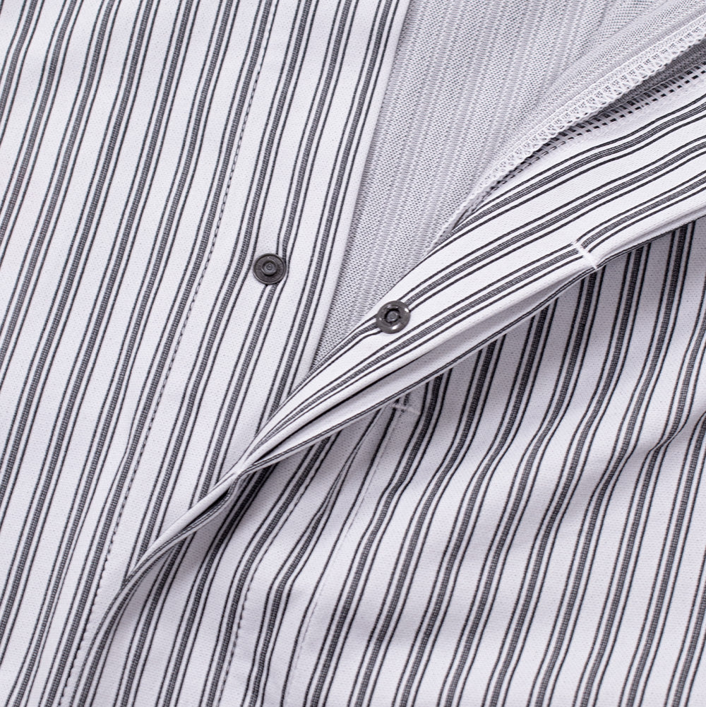Close-up shot of the concealed front button placket on the Oakley FGL Fuel LS Shirt, slightly parted to show the smooth breathable inner mesh weave, clean seam finishing, and low-profile metallic dark grey snap fasteners.