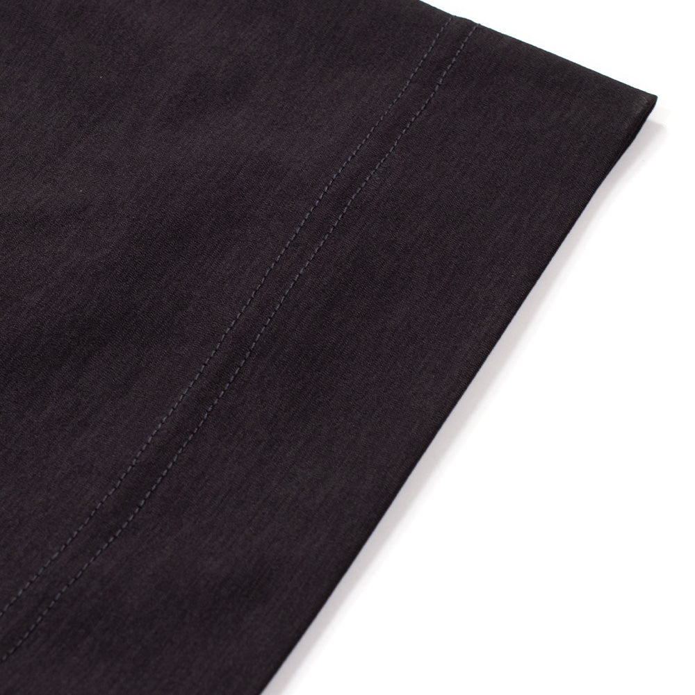 Macro studio shot of the bottom hem and side seam on the Oakley FGL Scratch SS Tee in Phantom, showing the parallel twin-needle stretch stitching along the fold and the dense, premium heathered knit texture of the technical material.