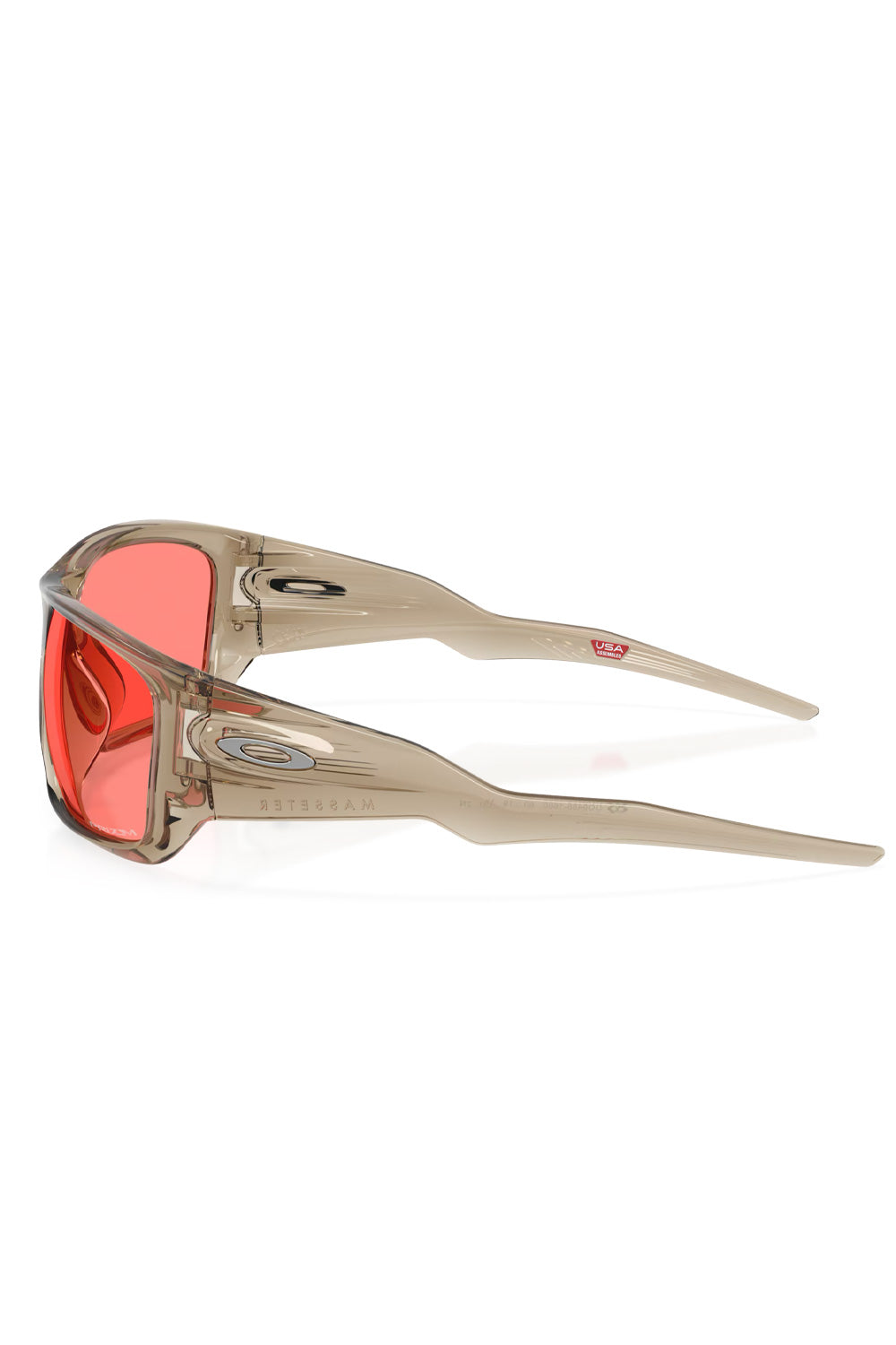 Side profile view of the Trans Sand O-Matter frame of the Oakley Masseter sunglasses, highlighting the silver Oakley ellipse logo and wide temple structure.