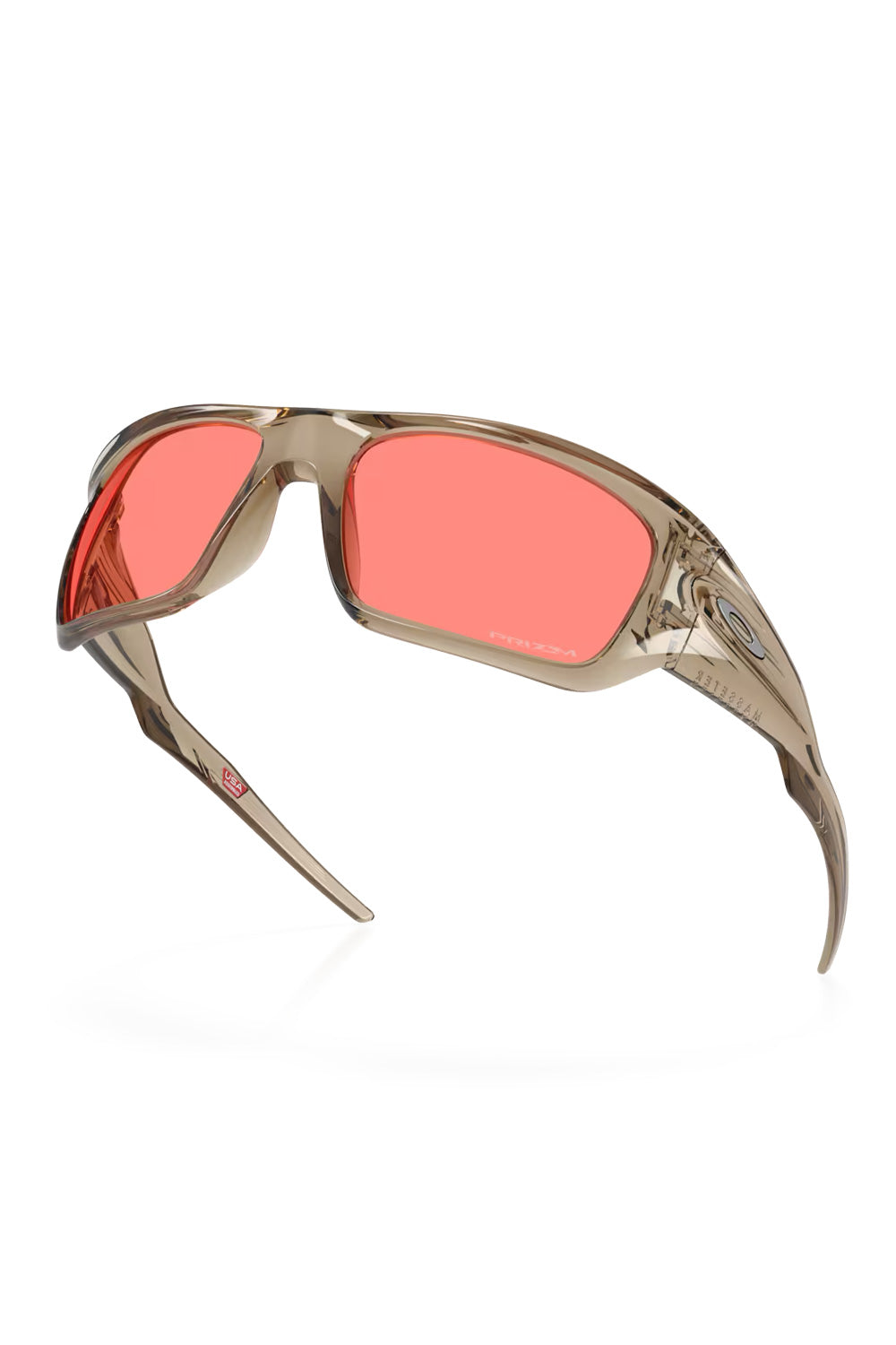 Dynamic angled view of the Oakley Masseter sunglasses showing the inner temple details and the USA Assembled stamp inside the Trans Sand frame.