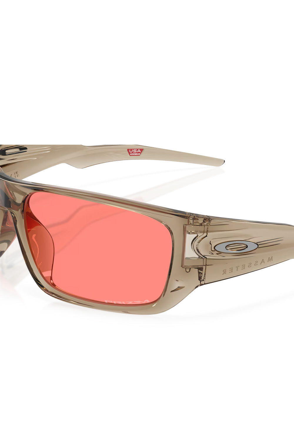 Close-up view of the Oakley Masseter frame hinge area, highlighting the silver ellipse logo on the temple and the Prizm etching on the peach lens.