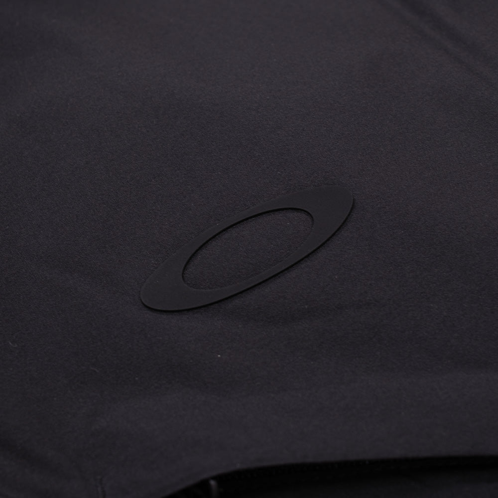 Detailed macro shot of the chest logo on the Oakley Retrofuel Gore-Tex Down Jacket, focusing on the subtle, matte black bonded rubber Oakley Ellipse icon smoothly heat-pressed onto the windproof Gore-Tex Labs Windstopper shell.