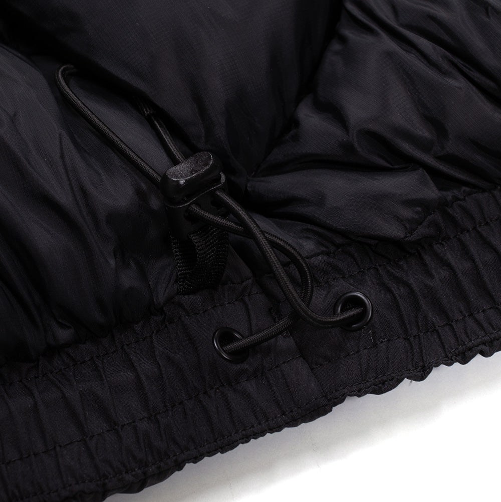 Detailed close-up shot of the interior bottom hem cinching system on the Oakley Retrofuel Gore-Tex Down Jacket, displaying the elastic drawcord anchored through a metal eyelet with an adjustable spring-loaded barrel stopper against black ripstop lining.
